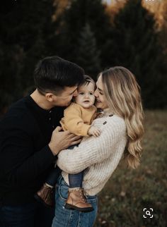 a man and woman holding a baby in their arms