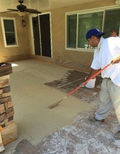 a man with a mop and bucket in front of a house that is being built