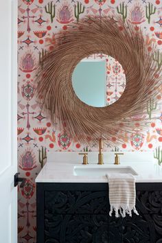 a bathroom vanity with a mirror and decorative wallpaper