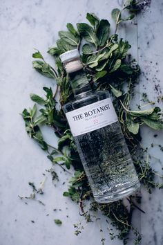 a bottle of gin on top of some leaves