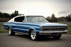 an old blue car is parked on the street