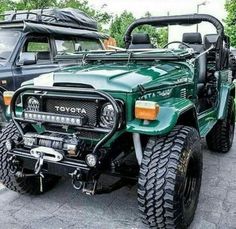 two green jeeps parked next to each other