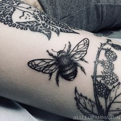 a black and white photo of a bee on a woman's arm with flowers