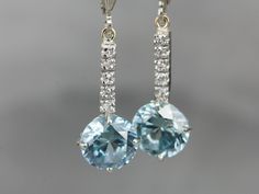 These lovely zircons are bright and bold! The color is cool, luscious sky blue, with plenty of sparkles! The long bar at the center is inlaid with sparkling diamonds, at the very top are the earring wires, hinged lever backs which are brand new, 14K white gold with a simple polished design. These are comfortable to wear and very secure! Metal: 14K White Gold Gem: 2 Blue Zircon totaling 6.81 Carats Gem Measurements: 8.2 mm, Round Accents: 10 Diamonds totaling .10 Carats, F in Color, VS in Clarity White Gold Drop Earrings, Edwardian Jewelry, Earring Wires, Cameo Ring, Fabulous Jewelry, Blue Zircon, Pretty Earrings, Gold Drop Earrings, Jewelry Patterns