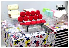 a bunch of red and white buttons sitting on top of a table next to each other