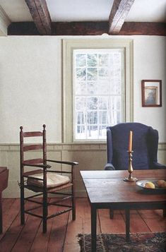 a living room filled with furniture and a wooden table in front of a large window