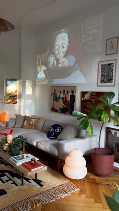 a living room filled with furniture and pictures on the wall