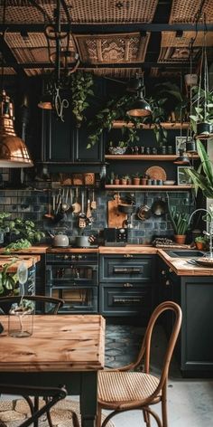 a kitchen filled with lots of green plants and wooden tables in front of black cabinets