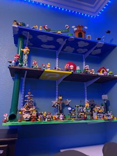 a shelf filled with lots of legos on top of a blue wall in a room