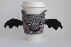 a crocheted coffee cup cozying with an adorable black bat design on it