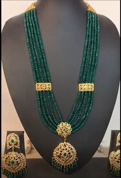 Regal, gold plated rani haar with multiple strings of high quality synthetic emeralds. Perfect choice for Indian, Pakistani and Bangladeshi weddings. The necklace is adjustable by drawstring and falls on the bosom. The Earrings are push-ins and are approximately 3.5 inches in length. Traditional Gold-plated Emerald Necklace For Wedding, Gold Chandbali Emerald Necklace For Wedding, Gold Emerald Necklace With Round Beads For Festive Occasions, Gold Bridal Necklace With Emeralds, Gold Emerald Bridal Necklace With Hand Set, Elegant Green Temple Necklace With Latkans, Gold Emerald Kundan Necklace For Weddings, Gold Kundan Necklace With Emerald For Wedding, Bollywood Style Gold Emerald Necklace For Festivals