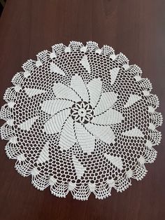 a white doily sitting on top of a wooden table