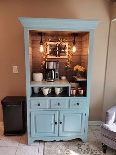 a coffee bar made from a hutch in the corner of a room with lights on