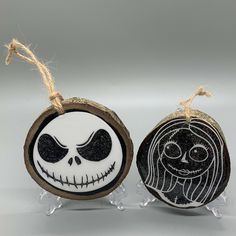 two halloween ornaments with faces on them are sitting next to each other, one is black and white