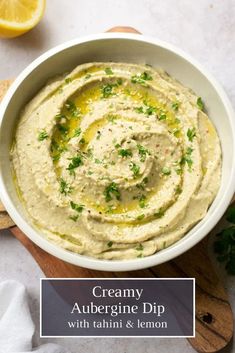 a white bowl filled with hummus and garnished with parsley