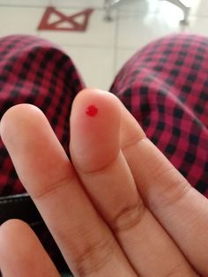 a person with red nail polish on their thumb