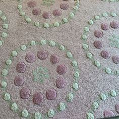 a pink and green rug with circles on it