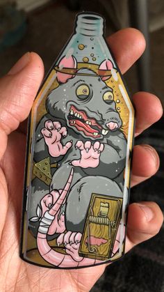 a person holding up a bottle with an image of a rat on it's side