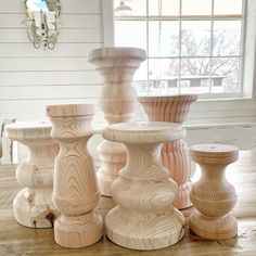 several wooden vases are stacked on top of each other in front of a window