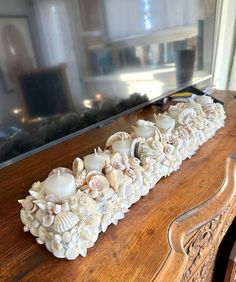 a wooden table topped with lots of shells and seashells on top of it