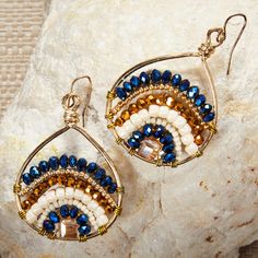 a pair of earrings sitting on top of a rock