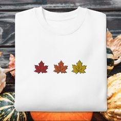 This Maple Leaf Sweatshirt is perfect for fall lovers and those seeking a touch of elegance and coziness, this sweatshirt is a statement piece that seamlessly combines seasonal charm and timeless style! Etsy/Tiktok: @cronchyleavesshop With our Maple Leaf Embroidered Sweatshirt, you can immerse yourself in the enchantment of autumn while showcasing your love for handcrafted artistry. Each sweatshirt is carefully created to be a cozy and stylish homage to the beauty of nature during the fall season. To ensure a perfect fit, please consult the size chart and follow the care instructions for your sweatshirt to maintain its exquisite appearance. Add a touch of autumn elegance to your wardrobe with our Maple Leaf Embroidered Sweatshirt and embrace the spirit of the season wherever you go. Happy White T-shirt With Embroidered Text For Fall, White Floral Embroidered Sweatshirt For Fall, White T-shirt With Custom Embroidery For Fall, Custom Embroidered White T-shirt For Fall, White Custom Embroidered T-shirt For Fall, Fall Crew Neck Sweatshirt With Machine Embroidery, Fall Long Sleeve T-shirt With Machine Embroidery, Long Sleeve T-shirt With Machine Embroidery For Fall, White Embroidered Text T-shirt For Fall