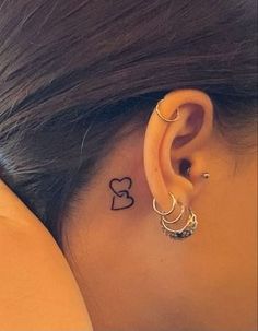 a woman's ear with the word love tattooed on her left behind the ear