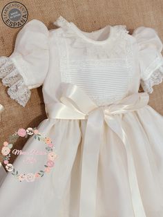 Beautiful classic Spanish christening baby unisex gown made with high-quality materials to commemorate an unforgettable day. Includes GOWN (dress) + BONNET (hat). Short puffy sleeves Made of high-quality ivory organza (we can make it in FULLY WHITE, just leave me a note about the color in your order). Adorned with lace to the shade of the dress. The gown is fully lined with soft, toned cotton fabric to provide baby comfort. Removable satin bow at the waist Includes matching hat/bonnet as a perfe Elegant Baptism Dress With Lace Trim And Organza, Organza Baptism Dress With Lace Bodice For First Communion, White Organza Baptism Dress With Lace Trim, Cream Ruffled First Communion Dress For Baptism, White Organza Baptism Dress With Ruffles, Elegant Organza Baptism Dress For Ceremony, Elegant Organza Baptism Dress, Elegant Cream Organza Baptism Dress, Organza Baptism Dress With Lace Bodice For Confirmation