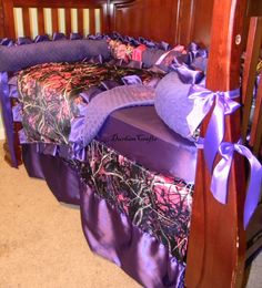 a baby crib with purple and pink bedding