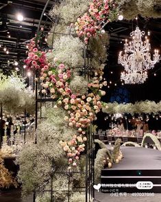 an elaborately decorated table with flowers and chandelier hanging from it's ceiling