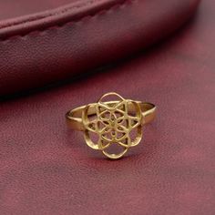 a gold ring sitting on top of a red leather surface