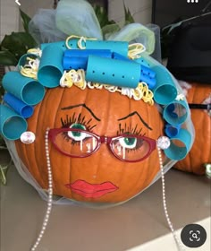 a pumpkin that has been decorated with hair clips and eyeglasses on it's head