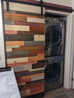 a washer and dryer in a room with wood paneling on the wall