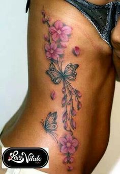 a woman's back with pink flowers and butterflies on it