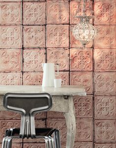 a table with two chairs and a vase on it next to a chandelier