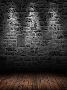 an empty room with brick walls and wooden floors, lit by lights from the ceiling