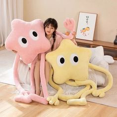 a woman sitting on top of a bed next to an octopus pillow and stuffed animal