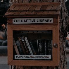 a tree with a sign on it that says free little library