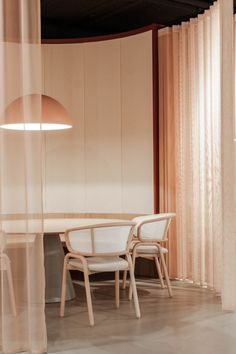 a table and chairs in a room with sheer curtains