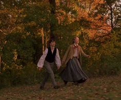 two people are walking in the woods together