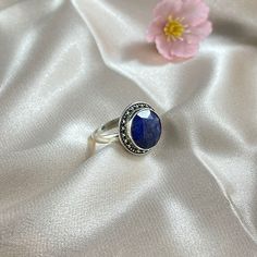 Aurora is a beautiful ring featuring a smooth round cushion cut Lapis Lazuli nestled in a finely detailed, sterling silver frame. Aurora is the perfect pick-me-up when you need that extra sparkle with it's ethereal, vintage-inspired design in silver. Authentic Sivalya Lapis Lazuli Lapis Lazuli: Inner Power - Wisdom - Manifestation Hallmarked Metal: 925 Sterling Silver Gemstone Size: 10mm x 10mm Cut: Round Shaped Smooth Cabochon Classic Sapphire Cabochon Rings, Timeless Cabochon Sapphire Ring Gift, Timeless Round Cabochon Sapphire Ring, Timeless Gift Sapphire Cabochon Ring, Adjustable Gemstone Signet Ring, Sterling Silver Timeless Birthstone Ring, Timeless Sterling Silver Birthstone Ring With Gemstone, Classic Sapphire Crystal Ring, Timeless Silver Round Birthstone Ring