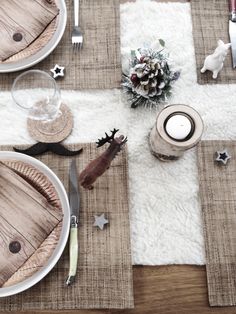 the table is set for christmas dinner with silverware and placemats on it