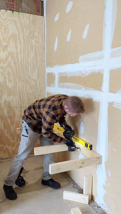 a man is working on the wall with tools