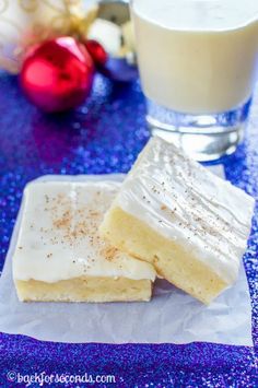 two pieces of cake sitting next to a glass of milk