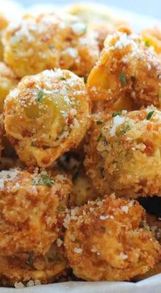 a white bowl filled with fried food covered in parmesan cheese and seasoning