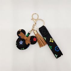 mickey mouse keychain with multicolored symbols on black fabric and tassel