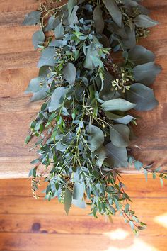 eucalyptus leaves and other greenery on a wooden table