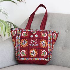 Featuring the traditional Kutch embroidery that is typical on Gujarat textiles, this shoulder bag is a standout. The bag is presented by SEWA, a non-profit that works to promote employment opportunities for women in India. Crafted from burgundy cotton, the shoulder bag is lavishly embellished with colorful embroidery and tiny mirrors. The fully lined tote features convenient interior pockets and a magnetic snap closure. Gujarat Textiles, Tiny Mirrors, Kutch Embroidery, Women In India, Colorful Embroidery, Embroidered Tote Bag, Embroidered Tote, Embroidery Bags, Employment Opportunities