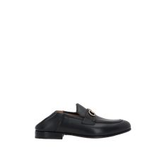 a black loafer with a gold buckle on the front and side, against a white background