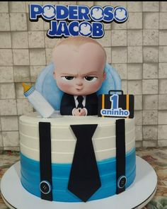 a cake with a baby in a suit and tie sitting on top of it's side